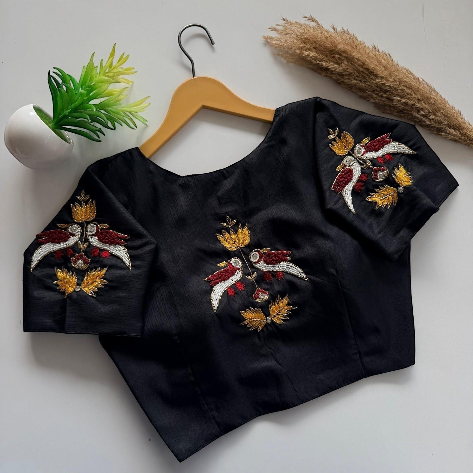 AMAB black haka silk blouse with intricate bird and leaf embroidery on sleeves and back. Padded designer partywear.