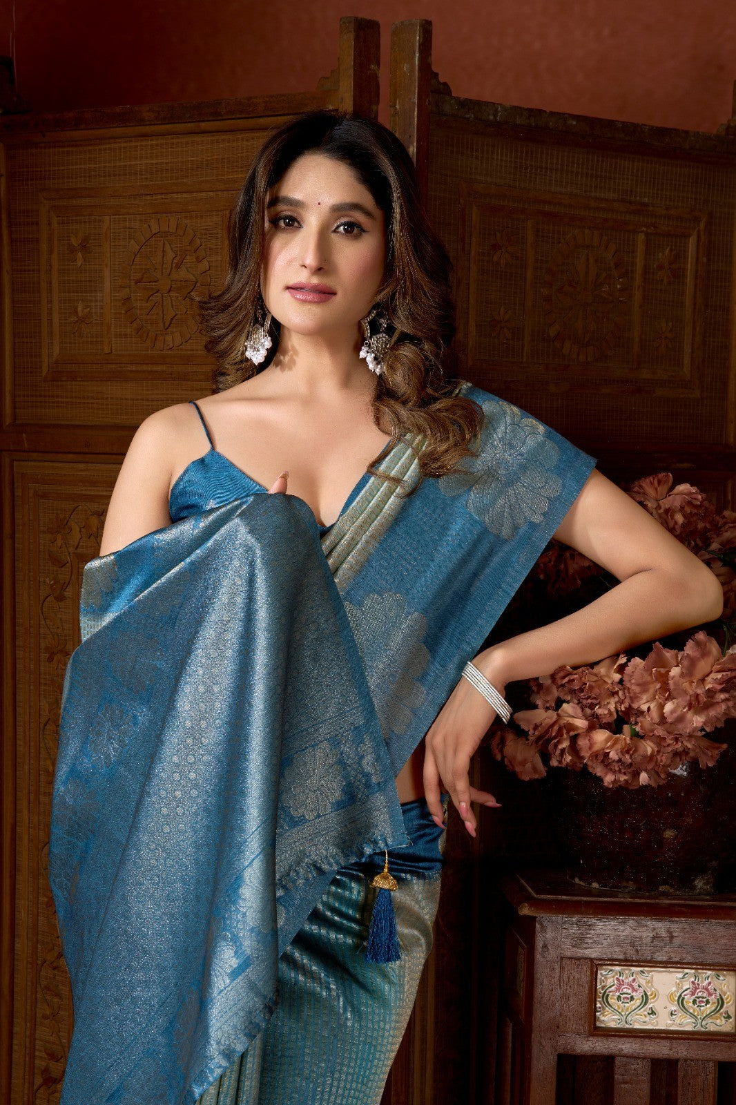 AMAB women's blue silk blend saree with woven floral motifs and metallic threads. Features a contrasting border and tassel detail.