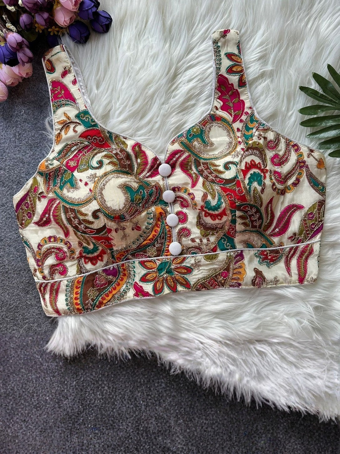 AMA B cream and multi-color paisley print crepe sleeveless blouse with white button detail and padded cups.