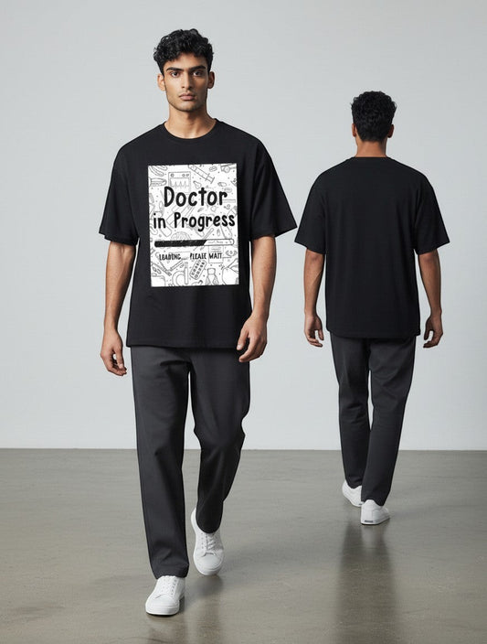 AMAB black cotton t-shirt with "Doctor in Progress Loading Please Wait" graphic and medical icons.