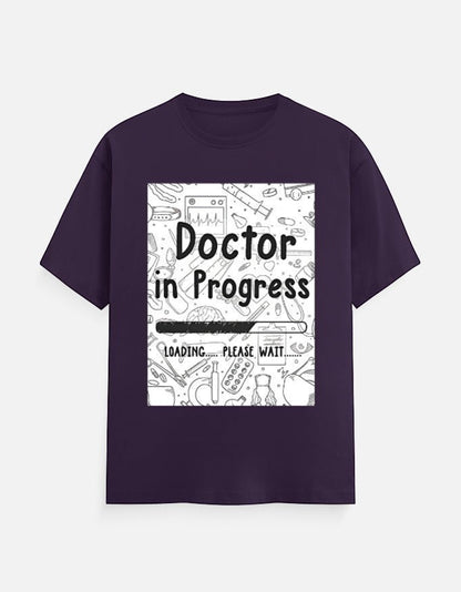 AMAB Doctor in Progress Loading Please Wait graphic t-shirt in deep purple cotton with medical icons.