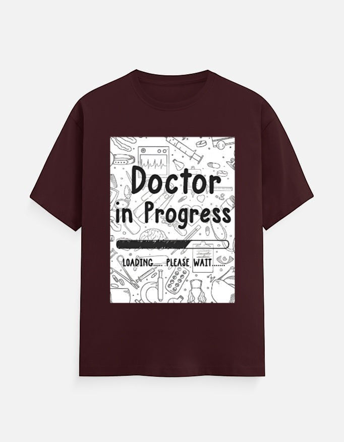 AMAB Doctor in Progress Loading Please Wait graphic t-shirt in maroon cotton with medical icons and loading bar design.