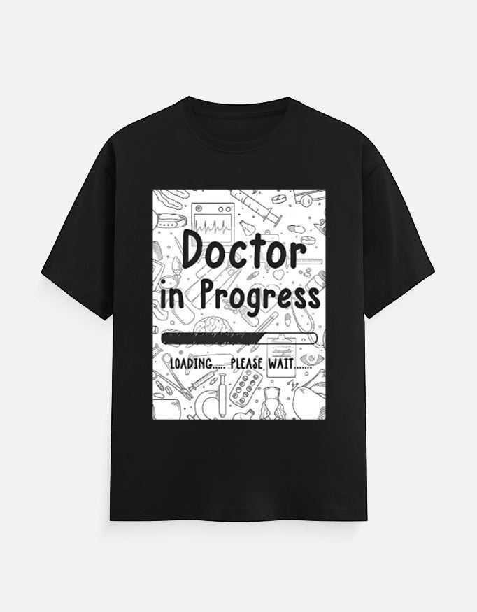 AMAB black cotton t-shirt with "Doctor in Progress Loading Please Wait" graphic and medical icons.
