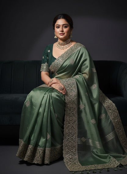 AMAB green silk blend saree with intricate embroidery and sequin work, paired with a matching blouse.