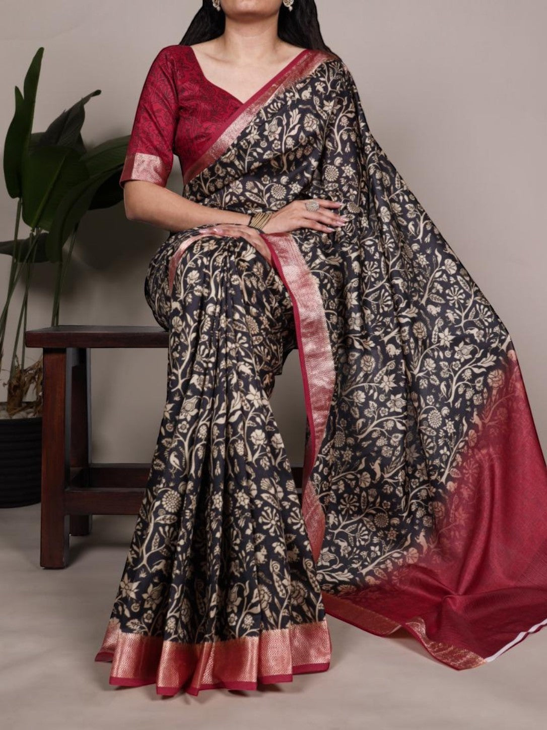AMAB dark floral print silk blend saree with gold border and maroon blouse. Features intricate floral motifs and a rich border.