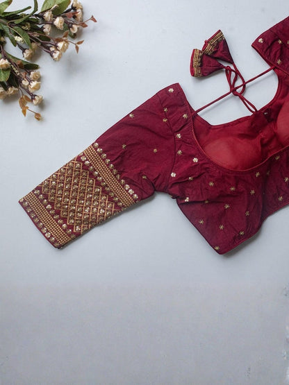 AMAB maroon Vichitra silk blouse with V-neck, zari and sequence embroidery, latkan detail, and 3/4 sleeves.