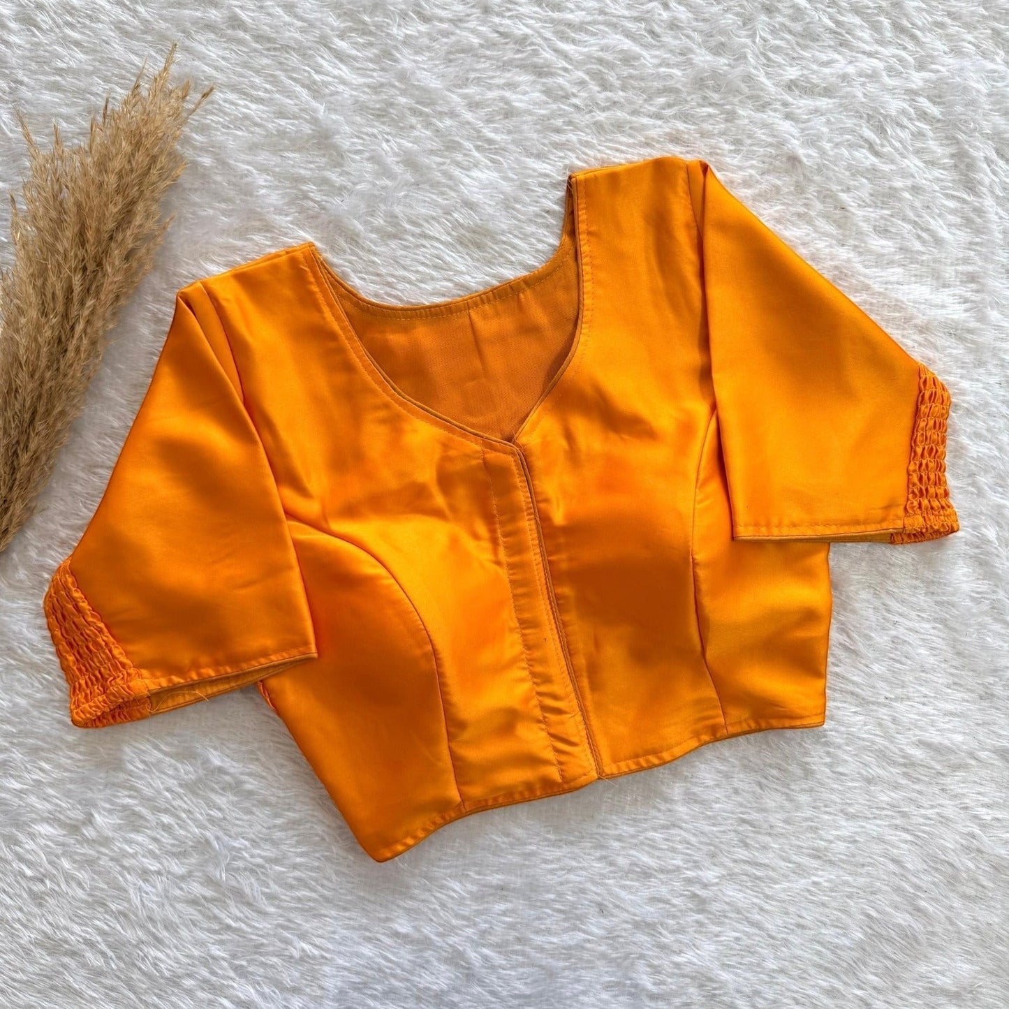 AMAB orange pure silk blouse with elastic fit and padded comfort. Features a V-neck and textured sleeves.