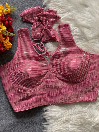 AMAB pink heavy georgette partywear blouse with intricate embroidery and sequence work, deep neck, and tie-up back. Includes matching fabric pieces.