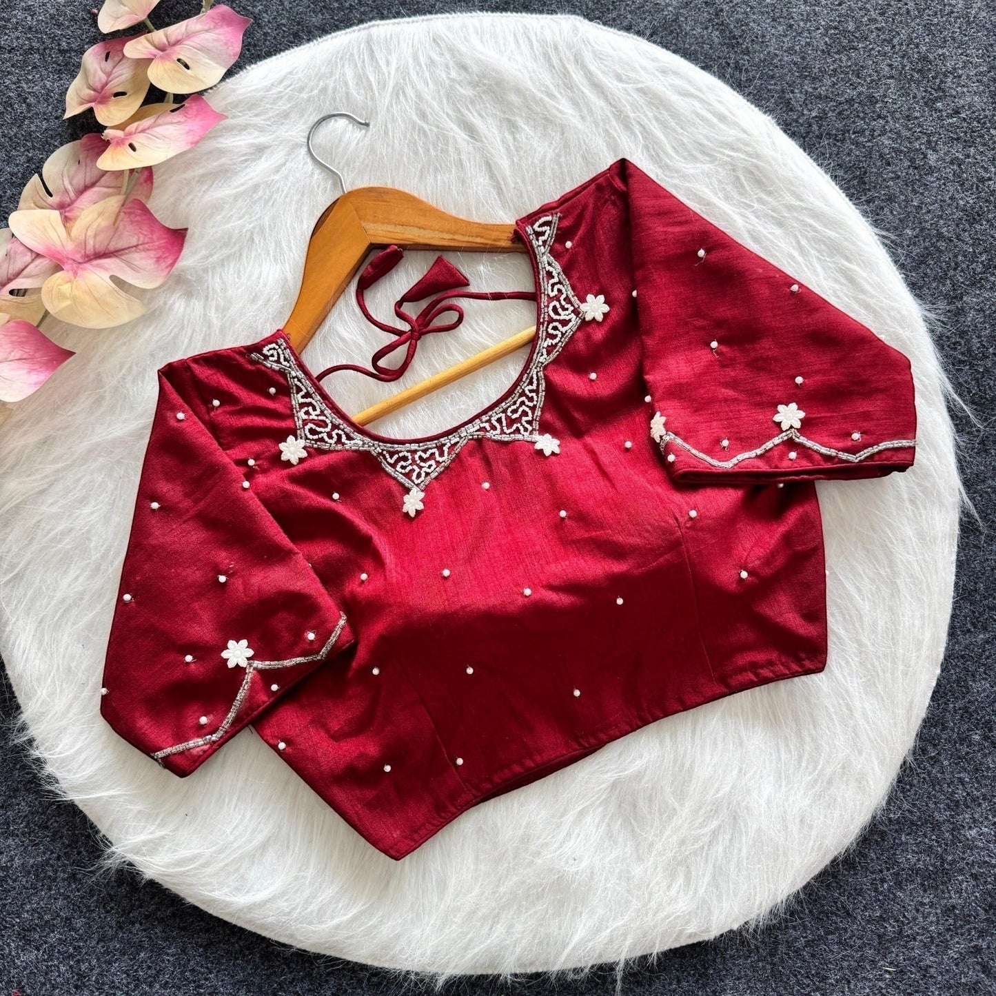 AMAB red silk blouse with all-over handwork, pearl embellishments, and padded design. Features intricate neckline and sleeve detailing.