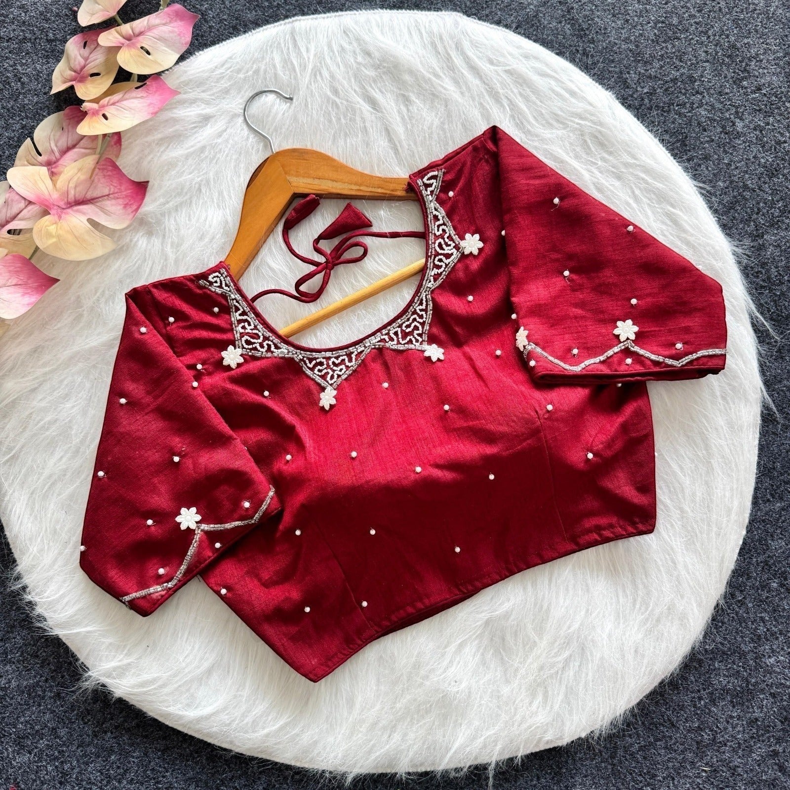 AMAB red silk blouse with all-over handwork, pearl embellishments, and padded design. Features intricate neckline and sleeve detailing.