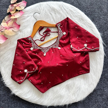 AMAB red silk blouse with all-over handwork, pearl embellishments, and padded design. Features intricate neckline and sleeve detailing.