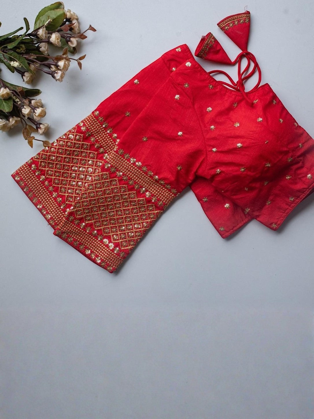 AMAB red Vichitra silk blouse with V-neck, front open, and gold zari sequence embroidery. Features latkan detail.