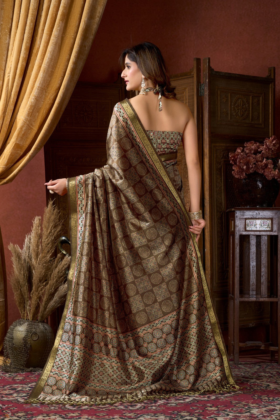 AMAB Traditional Indian silk blend saree in earthy brown with intricate geometric and floral motifs in red, blue, and cream. Gold border.
