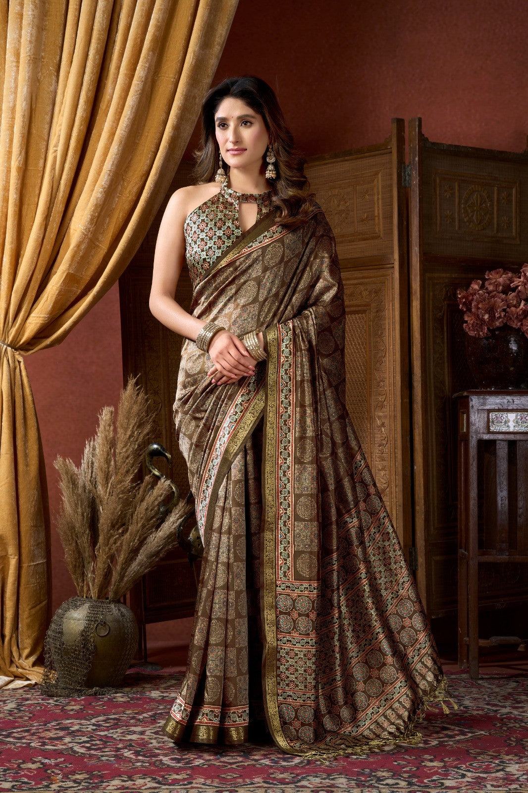 AMAB traditional Indian silk blend saree in earthy brown with intricate geometric and floral motifs in red, blue, and cream. Features a gold border and matching blouse piece.
