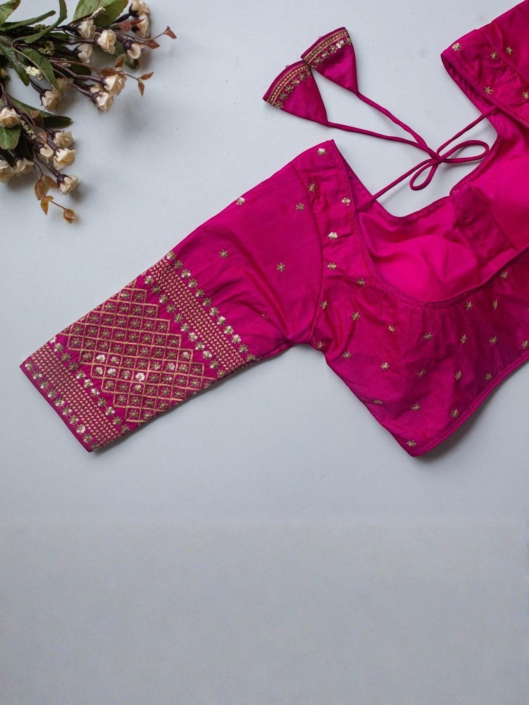 AMAB hot pink Vichitra silk blouse with V-neck, zari and sequence embroidery, and latkan detail. 3/4 sleeves.