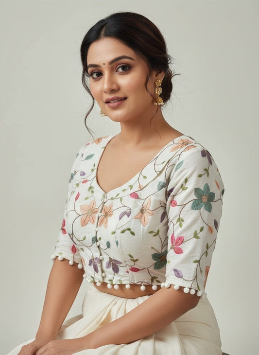 AMAB white cotton blouse with floral embroidery and pom-pom trim. Padded, dyeable fabric with thread and sequence detail.